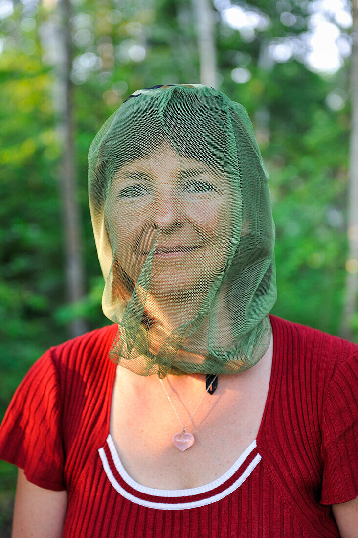 Frau trägt ein Moskitonetz auf dem Kopf, Region Saguenay, Provinz Quebec, Kanada, Nordamerika