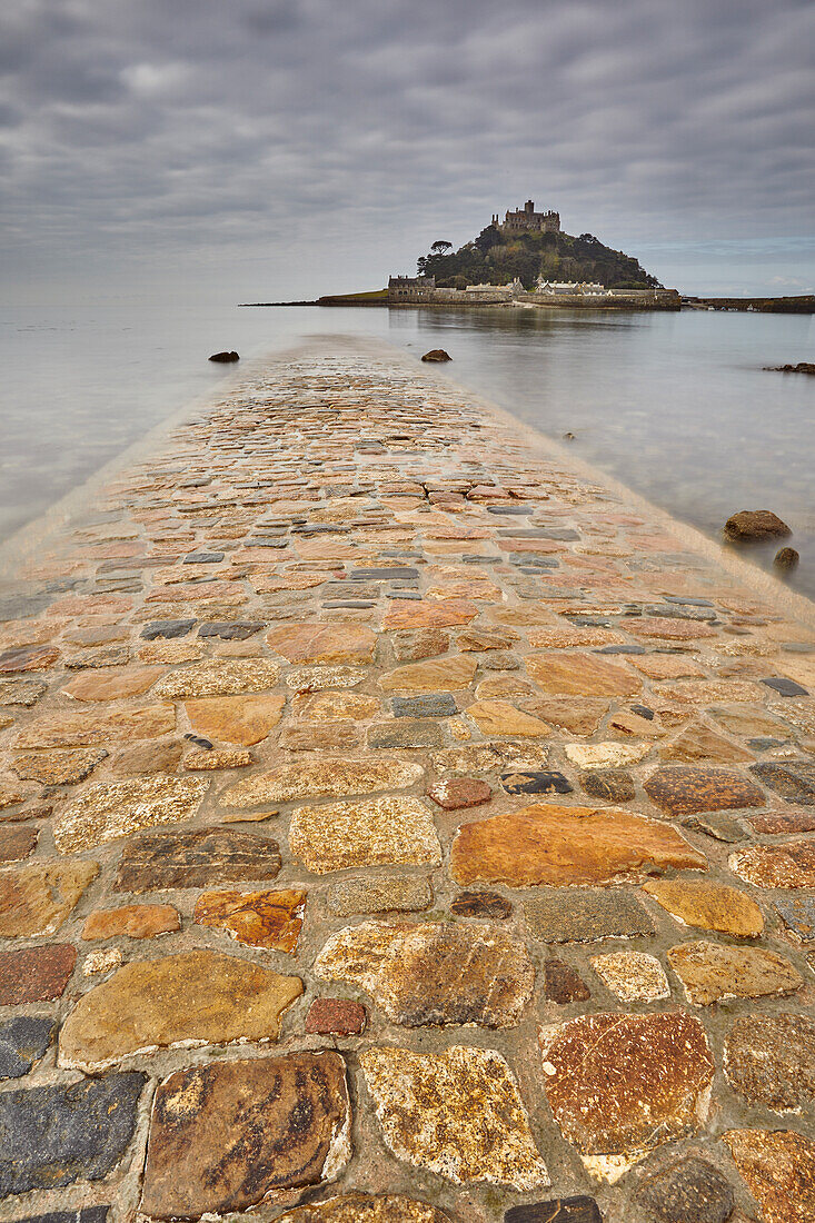 St. Michael's Mount im frühen Morgenlicht und bei abnehmender Flut, wobei der Damm zwischen der Insel und dem Festland bei Marazion noch weitgehend überflutet ist; Marazion, bei Penzance, Cornwall, England, Vereinigtes Königreich, Europa