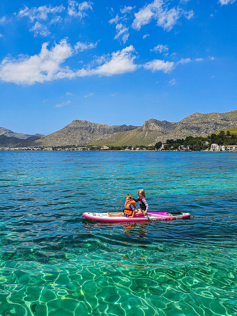 Mädchen auf einem SUP in den türkisfarbenen Gewässern der Halbinsel Formentor, Mallorca, Balearen, Spanien, Mittelmeer, Europa