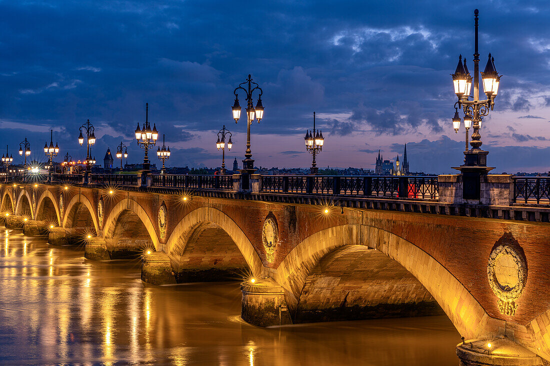 Historische Brücke, Pont de Pierre über die Garonne zur blauen Stunde (Abenddämmerung), Bordeaux, Gironde, Nouvelle-Aquitaine, Frankreich, Europa