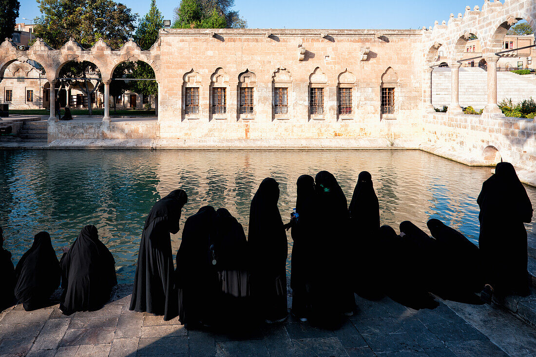 Muslimische Frauen in Abaya vor dem Abrahamsbecken, wo der Prophet von König Nimrod ins Feuer geworfen wurde, Sanliurfa, Türkei, Kleinasien, Asien