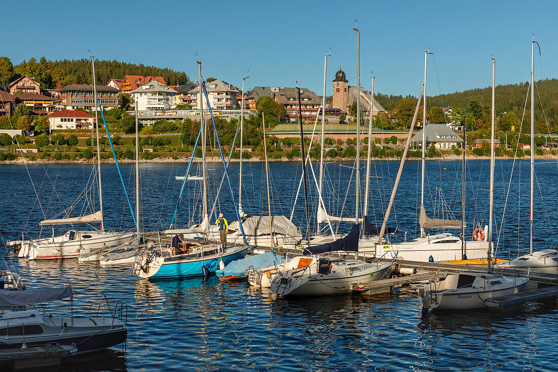 Boat dock with boats moored on water with view over Schluchsee, Schwarzwald (Black Forest), Baden-Wurttemberg, Germany, Europe