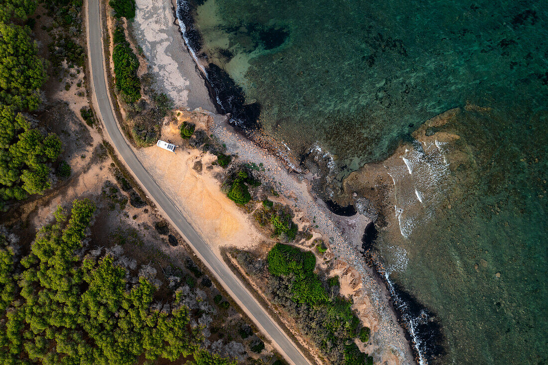 Luftaufnahme einer Drohne über einem Wohnmobil mit Solarzellen an der Küste Sardiniens, Sardinien, Italien, Mittelmeer, Europa