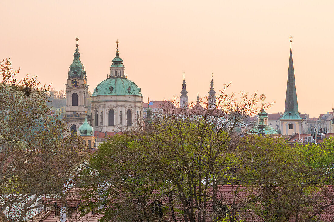 Tower and dome of St. Nicholas Church and St. Thomas Church in Lesser Town at sunset, Prague, Czech Republic (Czechia), Europe