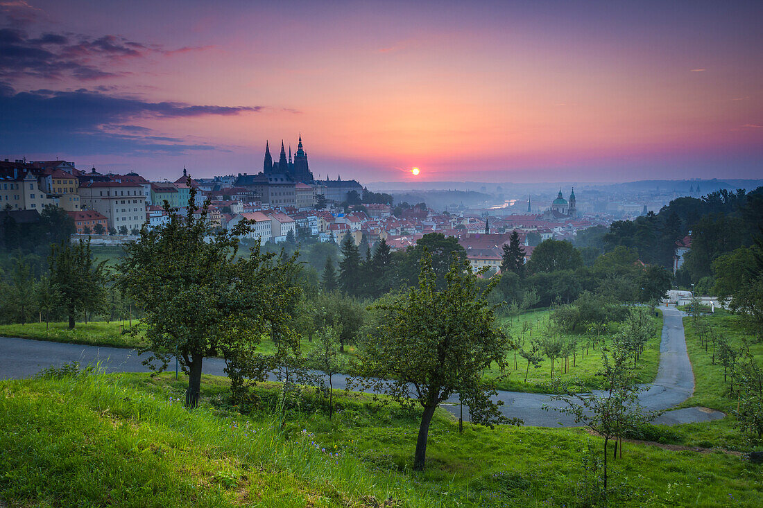 Prager Burg, St.-Nikolaus-Kirche und Gärten des Petrin-Hügels bei Sonnenaufgang, UNESCO-Welterbe, Prag, Tschechien, Europa