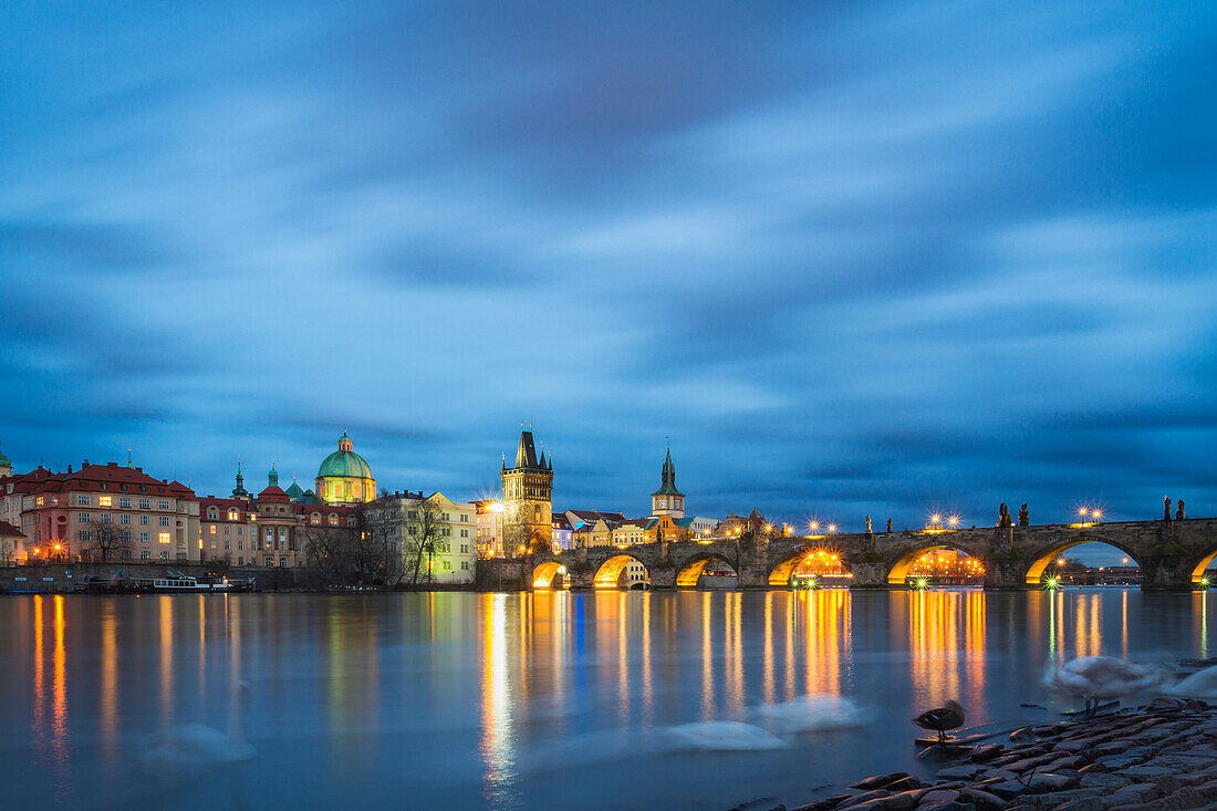 Charles Bridge, OId Town Bridge Tower and dome of St. Francis of Assisi Church by Vltava River at twilight, Prague, Czechia, Europe