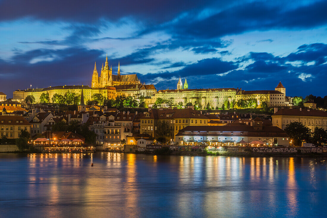 Beleuchtete Prager Burg über der Moldau in der Dämmerung, UNESCO-Weltkulturerbe, Prag, Tschechische Republik (Tschechien), Europa