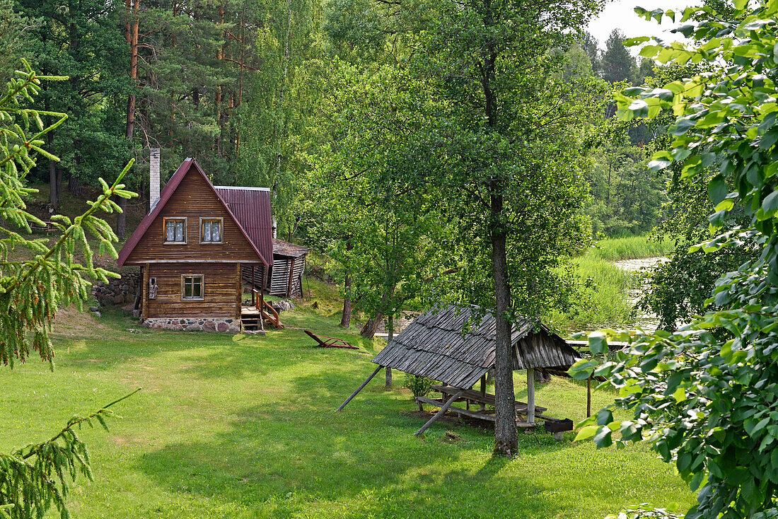 Typical wooden house on the edge of Ukojas lake, near Ginuciai, Aukstaitija National Park, Lithuania, Europe