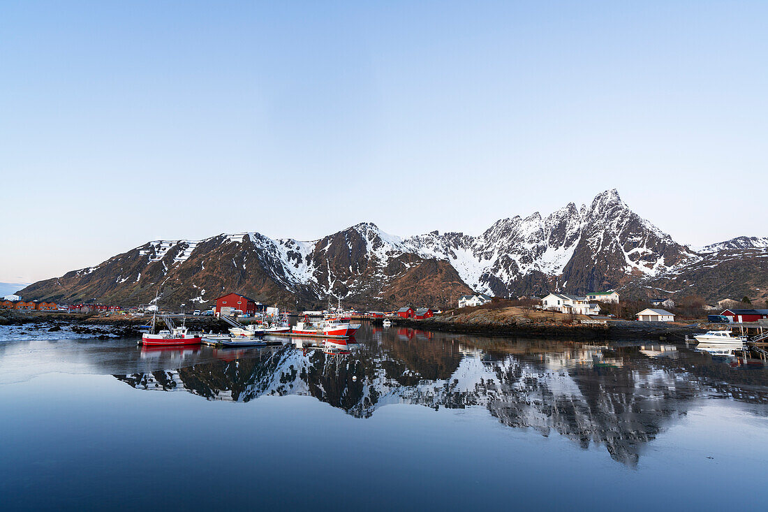 Ruhiges Wasser, in dem sich die arktische Landschaft des traditionellen Fischerhafens von Ballstad in der Morgendämmerung spiegelt, Vestvagoy, Lofoten, Norwegen, Skandinavien, Europa