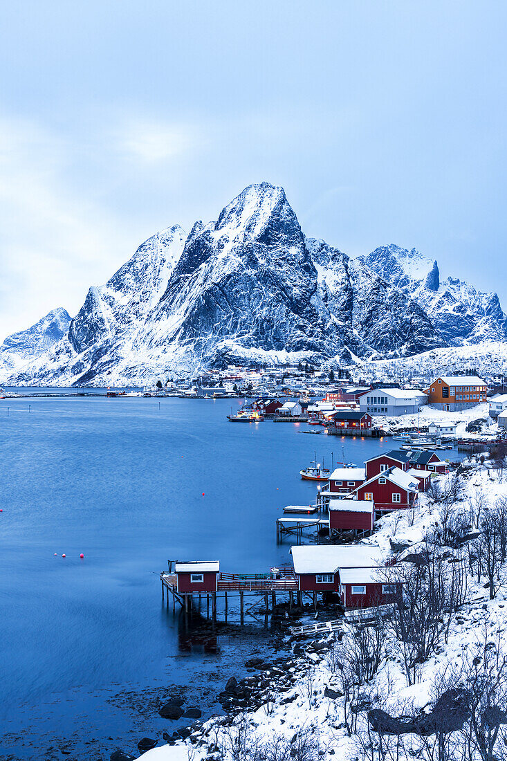 Abenddämmerung über dem traditionellen Fischerdorf Reine nach Schneefall, Reine, Lofoten-Inseln, Norwegen, Skandinavien, Europa