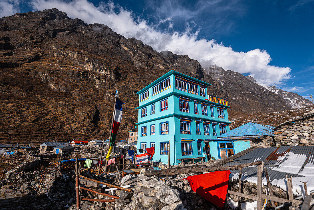 Türkisfarbene Berghütte vor hohen Bergen und Blick auf das Dorf Lang Tang, Himalaya, Nepal, Asien