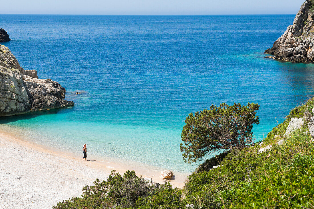 Frau spaziert am Strand der Dafines-Bucht, Halbinsel Karaburun, innerhalb des Karaburun-Sazan Marine Parc, Vlore-Bucht, Albanien, Europa