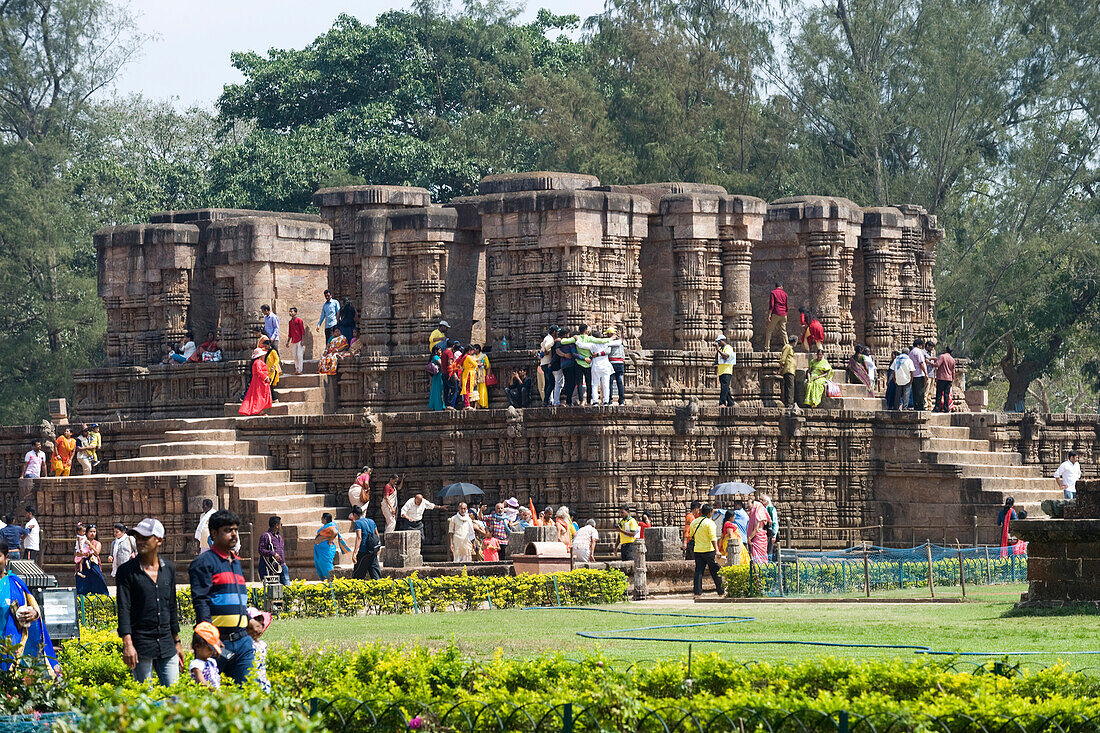 Pilgrims among ruins in the grounds of the mid 13th century Sun Temple, dedicated to Surya, the Hindu Sun God, constructed as a twelve-wheeled chariot drawn by seven horses, UNESCO World Heritage Site, Konarak, Puri District, Odisha, India, Asia