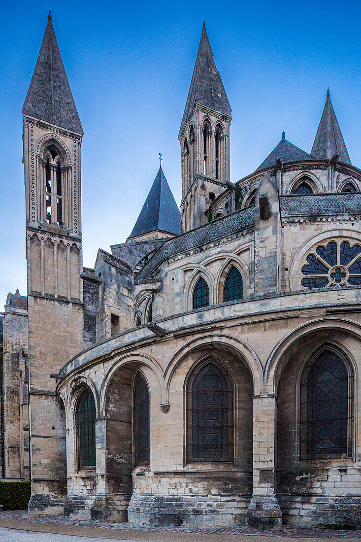 A stunning view of the historical Men's Abbey in Caen, Normandy, France during the blue hour, showcasing its beautiful architecture.