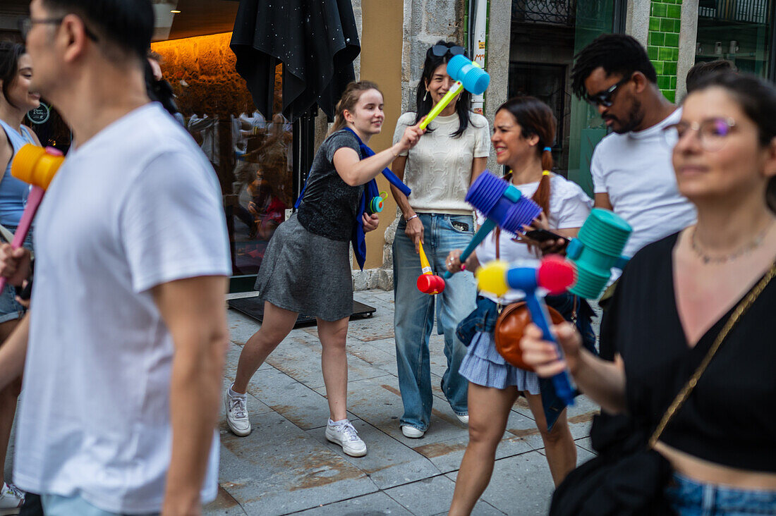 Begrüßung von Menschen mit welkem Lauch und Plastikhämmern während des Johannisfestes von Porto (Festa de Sao Joao do Porto ) in der Nacht zum 23. Juni (Johannisnacht) in der Stadt Porto, Portugal