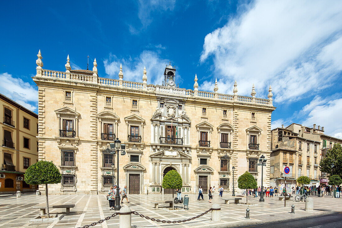 Beautiful view of Edificio de la Audiencia located in Plaza Nueva, Granada, España under a clear blue sky with visitors.