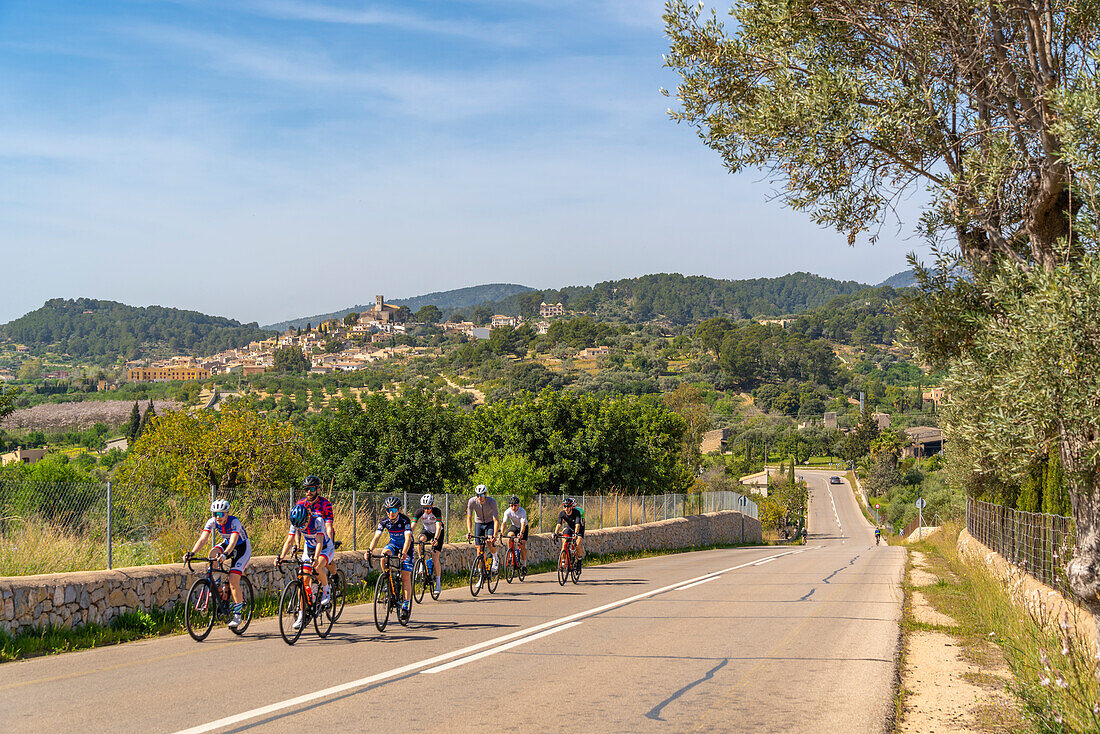 Blick auf Radfahrer und die auf einem Hügel gelegene Stadt Wolkenstein, Mallorca, Balearen, Spanien, Mittelmeer, Europa