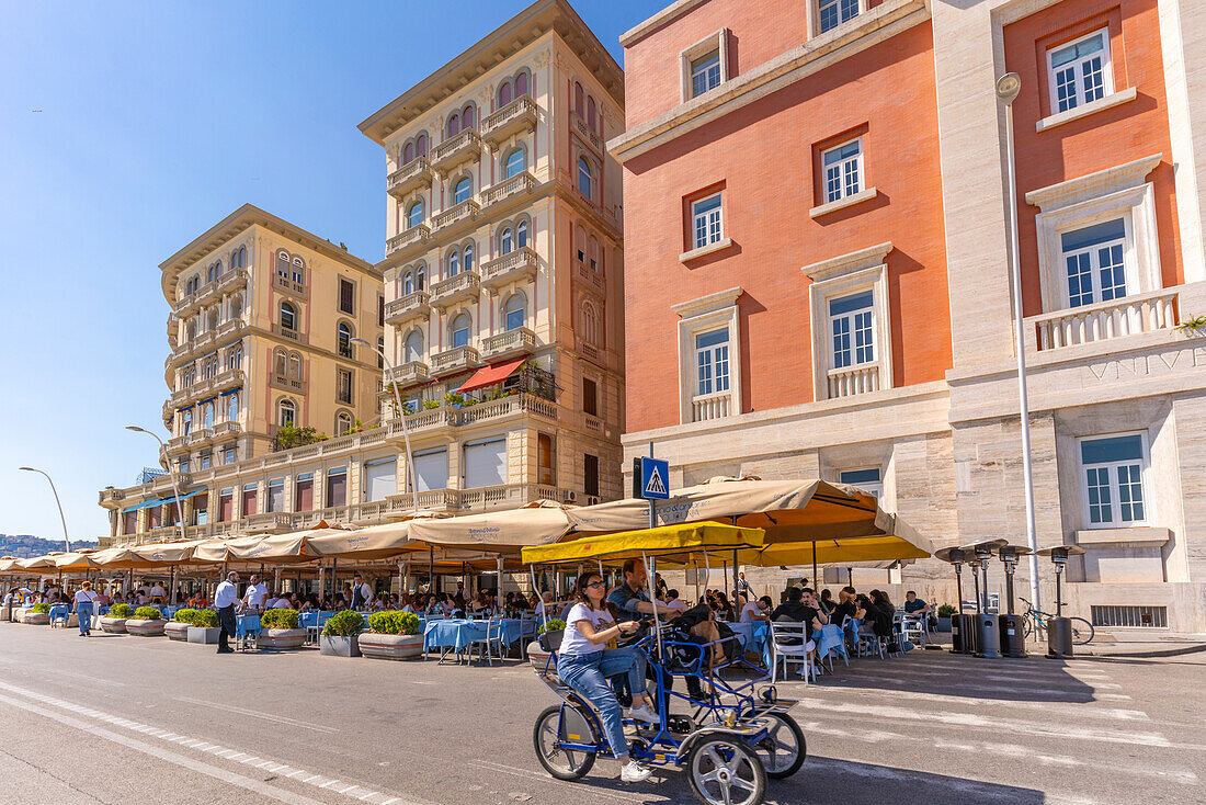 View of pastel coloured architecture, restaurants and cafes on seafront of Via Partenope, Naples, Campania, Italy, Europe