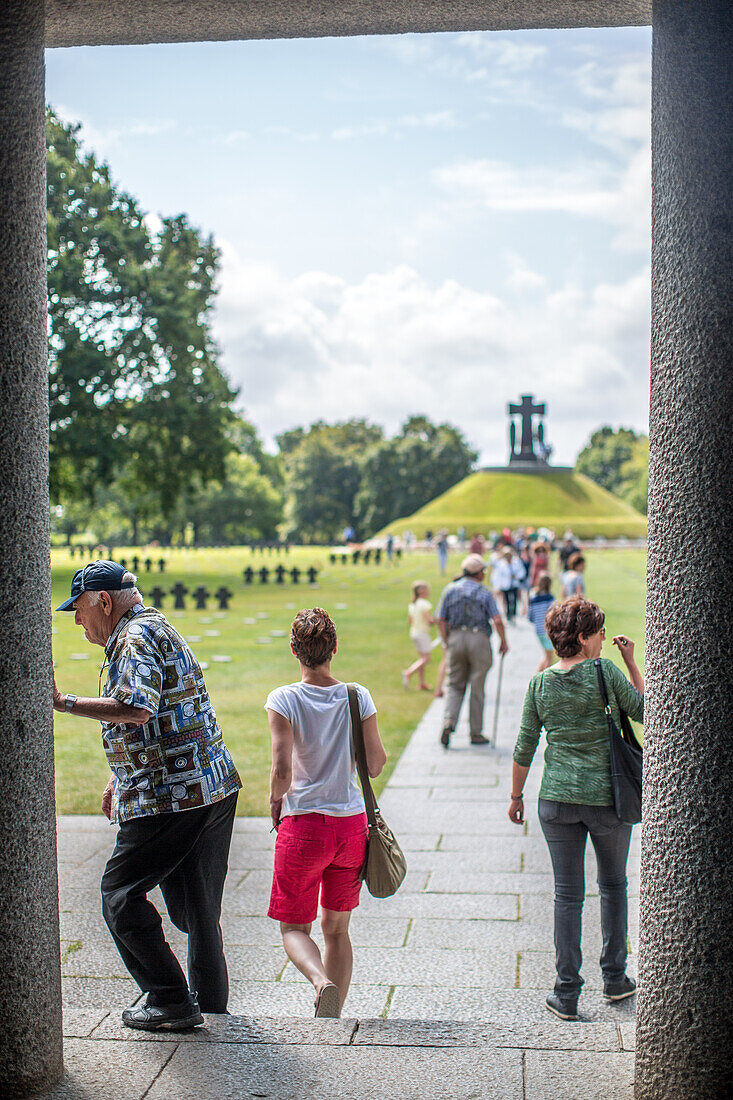 People walking around the German military cemetery in Normandy, France. It is a serene and historic site, providing a reflective space.