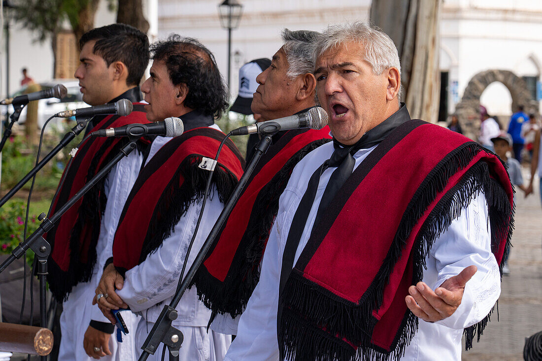 Gaucho singers in traditional outfits perform in the plaza at the festival of Saint Joseph's Day in Cachi, Argentina.