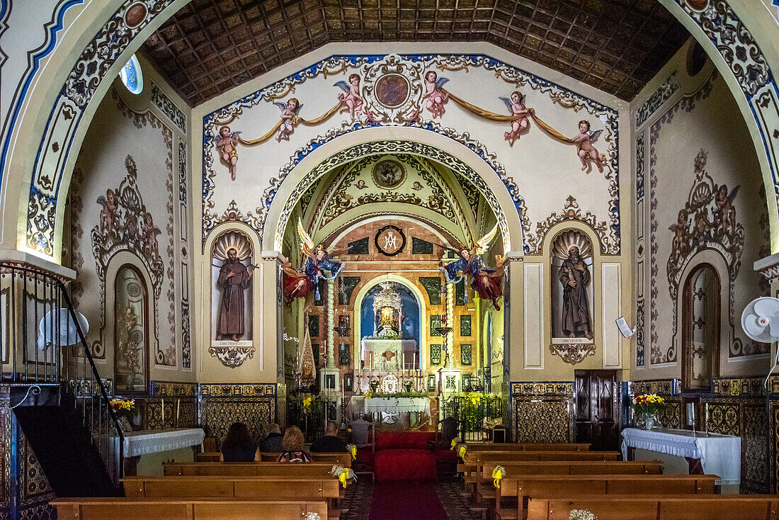 Dieses Foto zeigt das kunstvolle Innere der Ermita de la Reina de los Angeles mit ihren detaillierten Kunstwerken und religiösen Statuen in Alajar, Andalusien, Spanien.