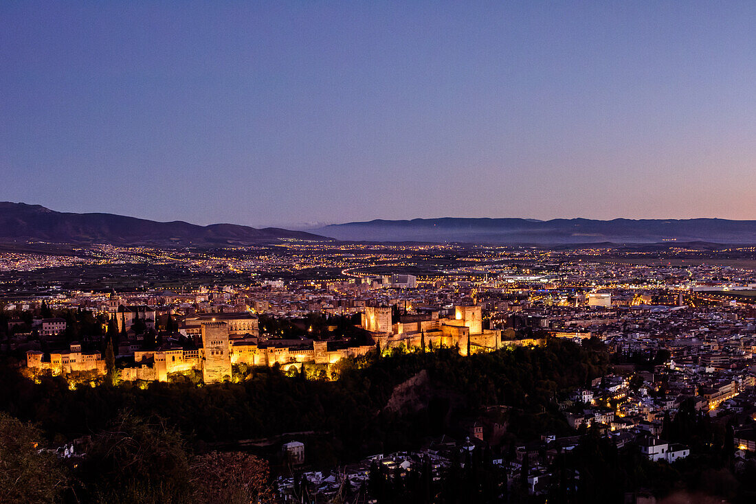 Atemberaubender Blick auf die Alhambra und das Stadtbild von Granada in der Dämmerung von San Miguel Alto aus. Ein schönes architektonisches und kulturelles Wahrzeichen in Andalusien, Spanien.