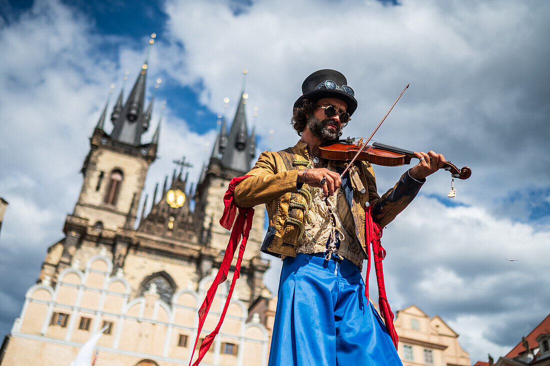 Artist plays violin while walking on stilts at the Parade of puppets from Marián Square to Old Town Square during the Prague Street Theatre Festival Behind the Door, Prague, Czech Republic