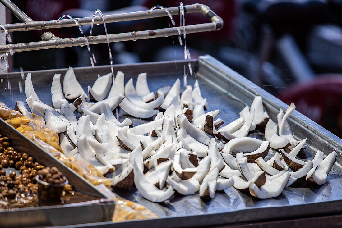 Frische Kokosnussscheiben, die auf der Feria de Sevilla in Sevilla, Spanien, zum Verkauf angeboten werden.