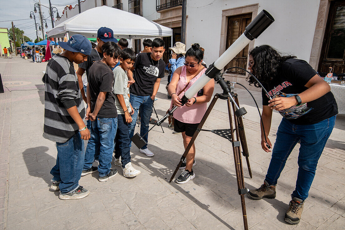 Gemeinschaft schaut durch ein Teleskop auf die Sonnenfinsternis 2024 in Mapimi, Mexiko.