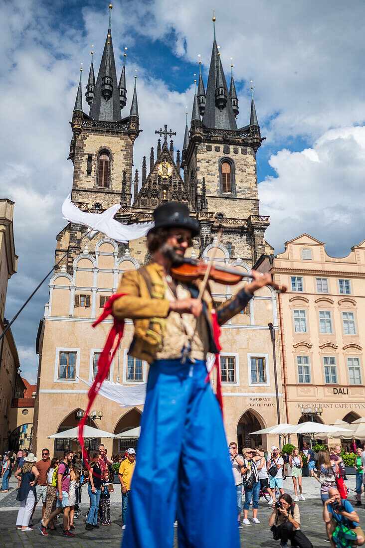 Artist plays violin while walking on stilts at the Parade of puppets from Marián Square to Old Town Square during the Prague Street Theatre Festival Behind the Door, Prague, Czech Republic