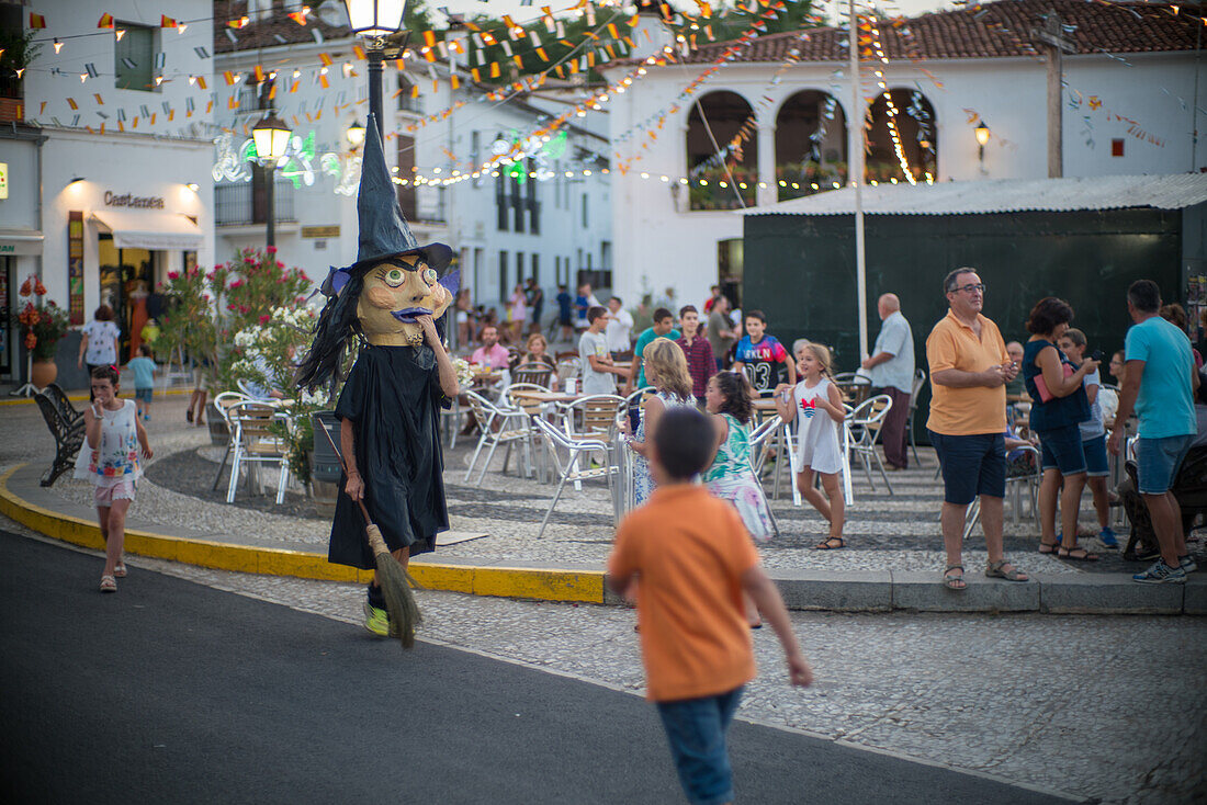 A lively festival in Fuenteheridos, Huelva, Andalucia, Spain, featuring the traditional gigantes y cabezudos parade with people enjoying the celebration.