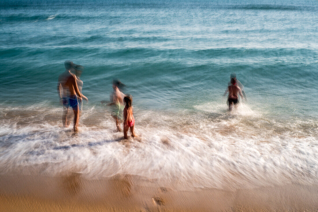 Blurred long exposure photo of people having fun at Zahora Beach in Cadiz, Spain. Captures movement and coastal vibrancy.