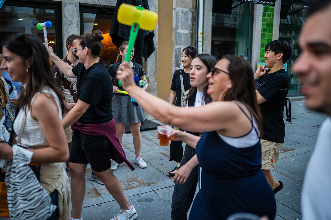 Begrüßung von Menschen mit welkem Lauch und Plastikhämmern während des Johannisfestes von Porto (Festa de Sao Joao do Porto ) in der Nacht zum 23. Juni (Johannisnacht) in der Stadt Porto, Portugal