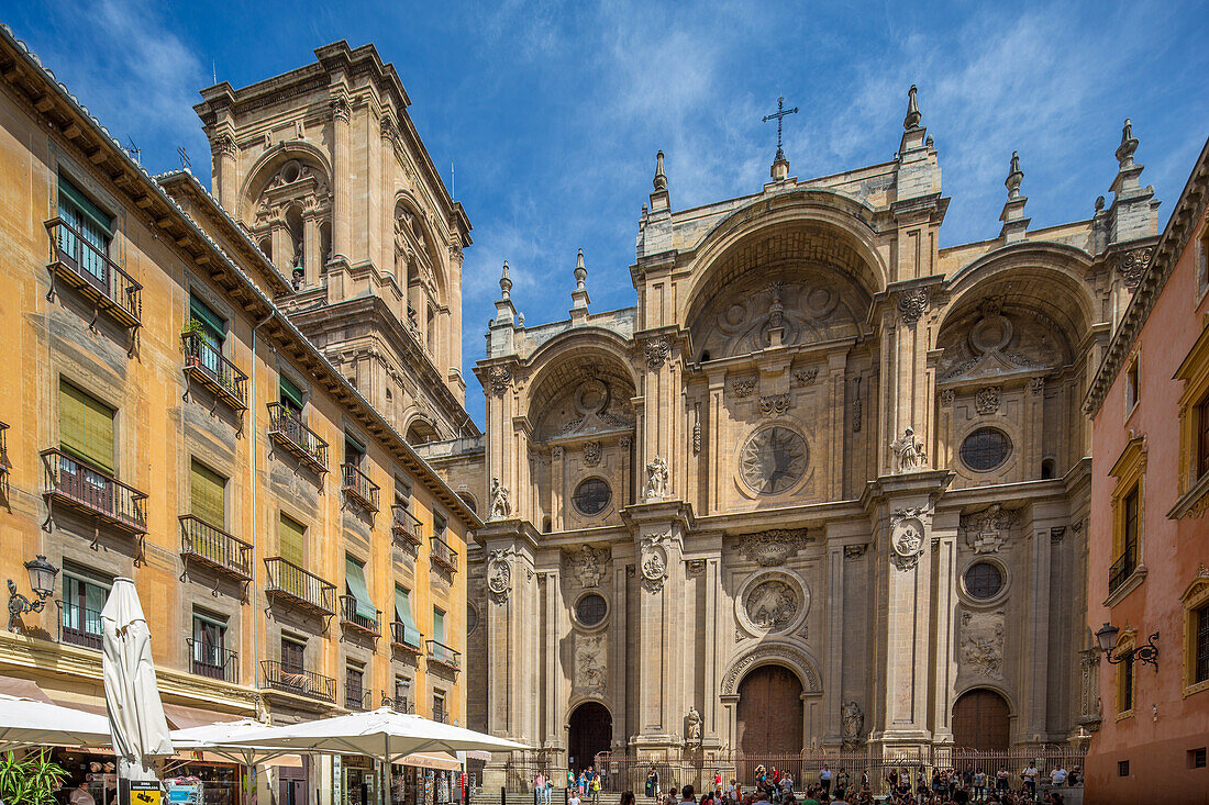 A beautiful view of the historic Catedral in Granada, España, with tourists gathered on a sunny day. The stunning architecture and vibrant atmosphere are showcased.