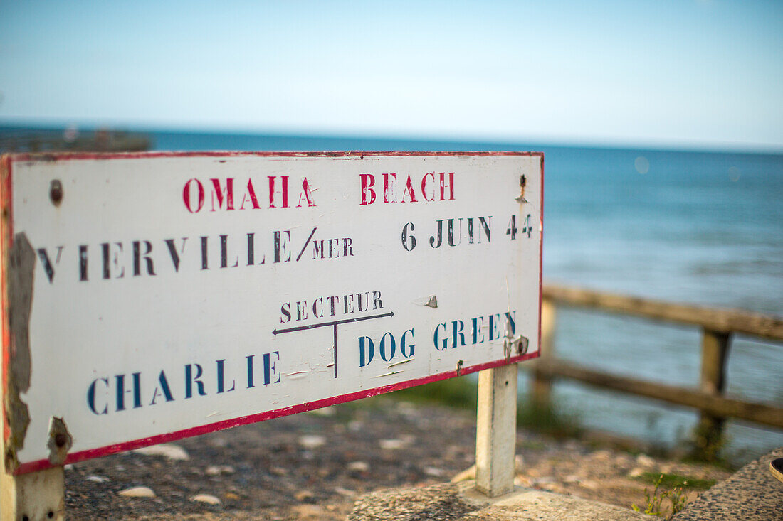 Ein altes Schild am Omaha Beach in der Normandie, Frankreich, das die historische Bedeutung des 6. Juni 1944 hervorhebt.