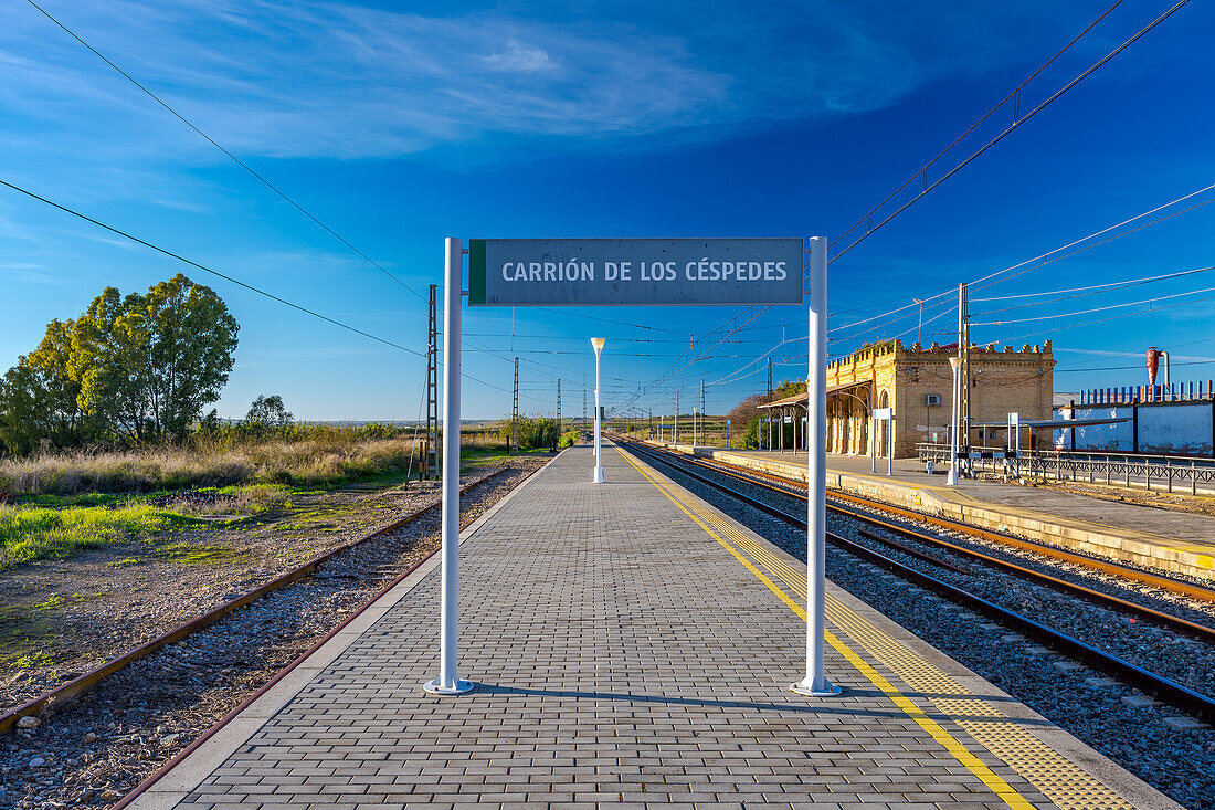 Ein malerischer Bahnhof in Carrion de los Cespedes, Sevilla, Andalusien, Spanien, in Sonnenlicht getaucht und mit offenem Himmel.