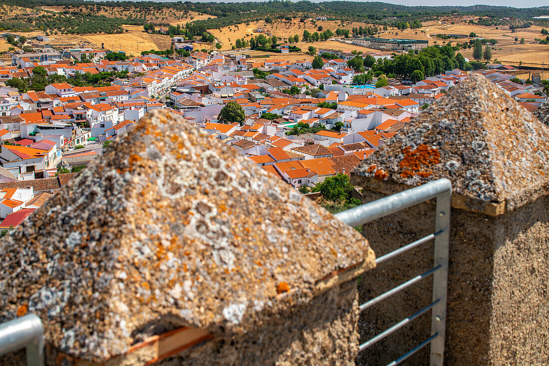 Malerischer Blick auf die Stadt Alanis de la Sierra mit ihren roten Dächern von einer historischen Burg in Sevilla, Spanien, aus gesehen.