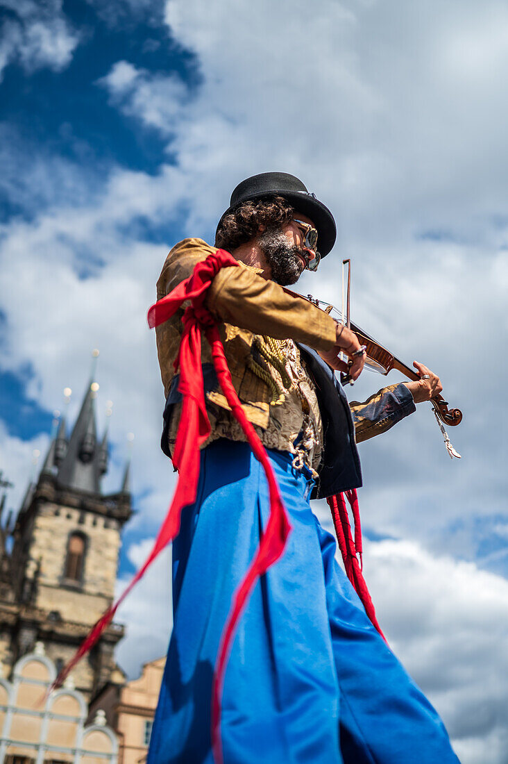 Artist plays violin while walking on stilts at the Parade of puppets from Marián Square to Old Town Square during the Prague Street Theatre Festival Behind the Door, Prague, Czech Republic