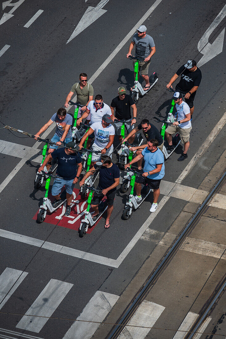 Gruppe von Touristen auf Motorrollern, Blick von oben, Prag