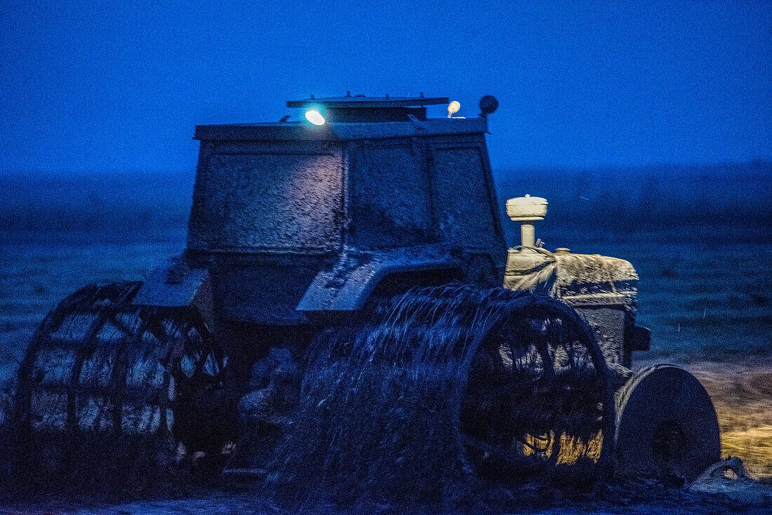 A tractor fitted with special wheels performs night time puddling of a rice field after harvest in Isla Mayor, Sevilla, Spain.