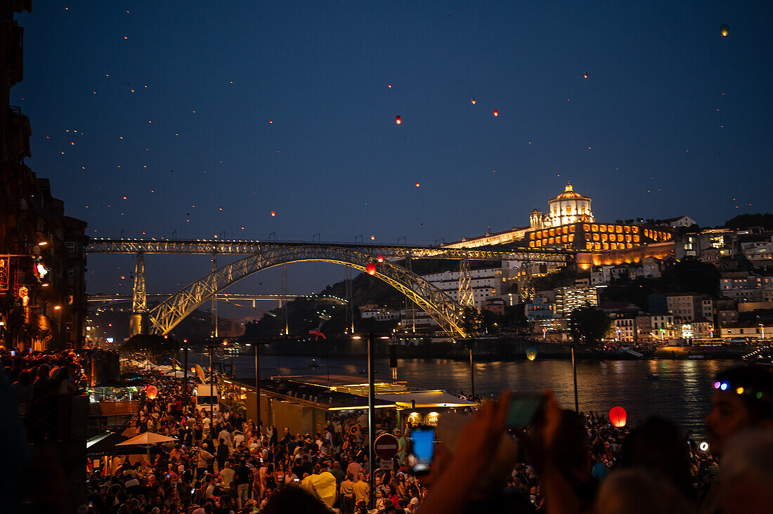 Heißluftballons, die während des Johannisfestes (Festa de Sao Joao do Porto ) in der Nacht zum 23. Juni (Johannisnacht) in der Stadt Porto, Portugal, über der Brücke Luis I und dem Fluss Douro starten