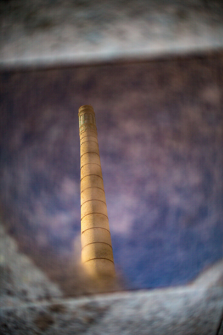 Chimney reflected in a puddle at the old Cartuja pottery factory, Centro Andaluz de Arte Contemporáneo, Sevilla, España.