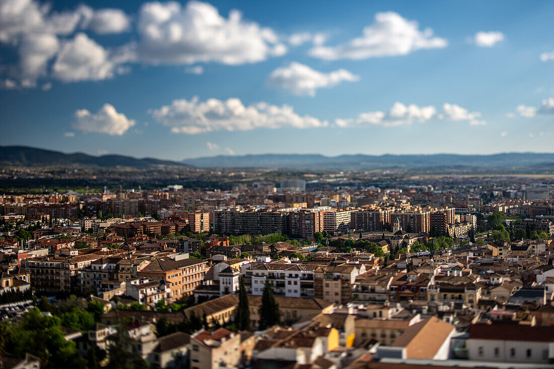 Malerische Tilt-Shift-Ansicht der Stadt Granada vom Alhambra-Hügel in Andalusien, Spanien. Erfasst die Stadtlandschaft und die entfernten Berge.