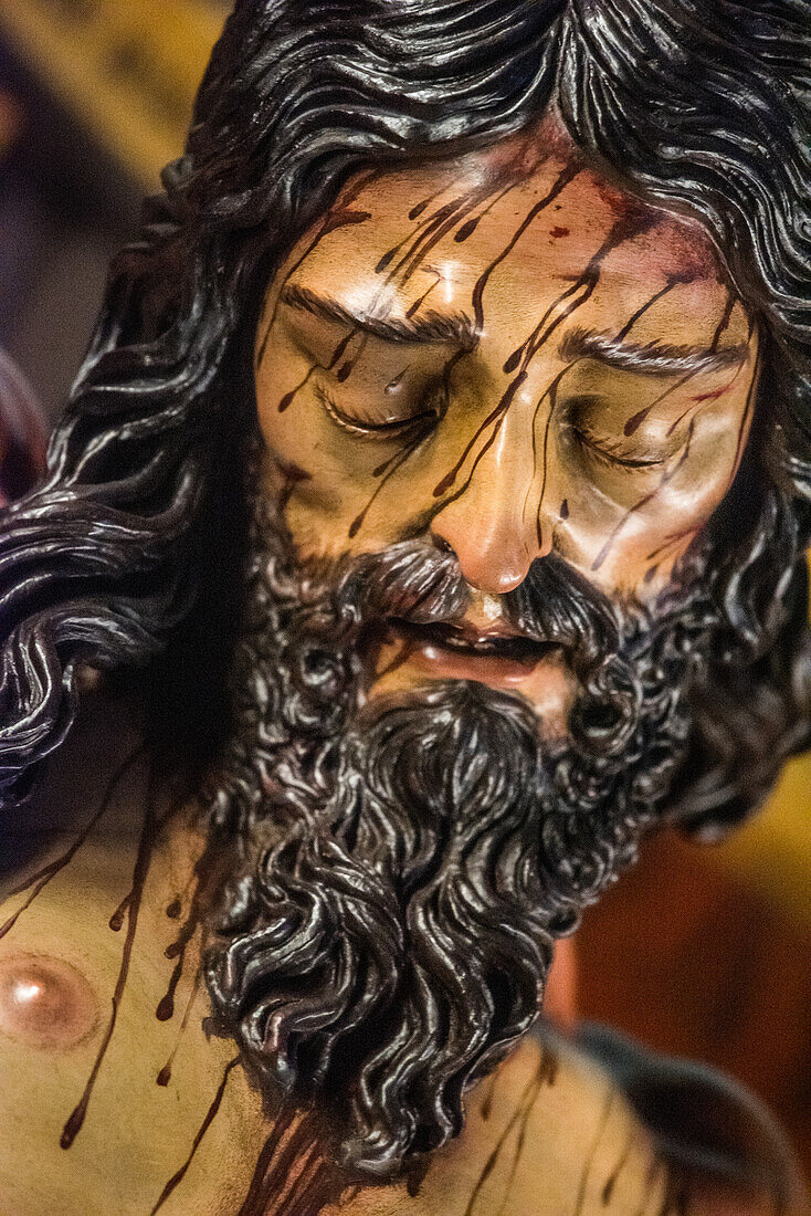 Close up of Cristo de la Vera Cruz, a 1972 sculpture by Francisco Buiza in Pilas, Seville, Andalusia, Spain. Depicts rich detail and emotional expression.