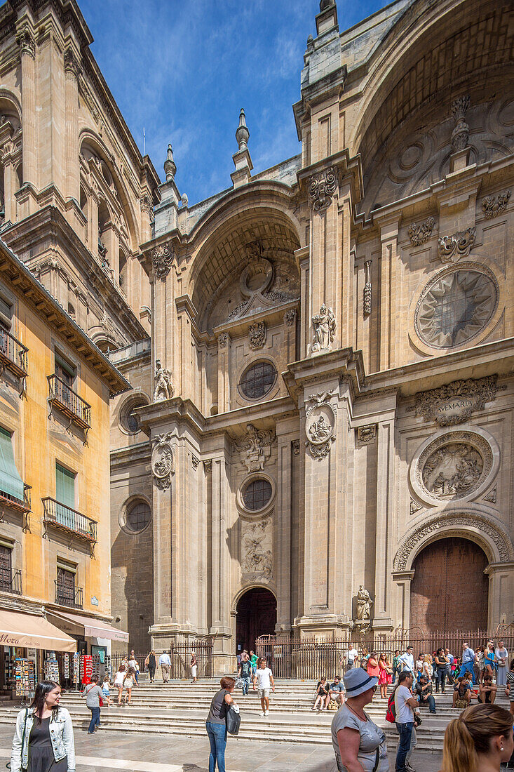 A beautiful view of the historic Catedral in Granada, España, with tourists gathered on a sunny day. The stunning architecture and vibrant atmosphere are showcased.