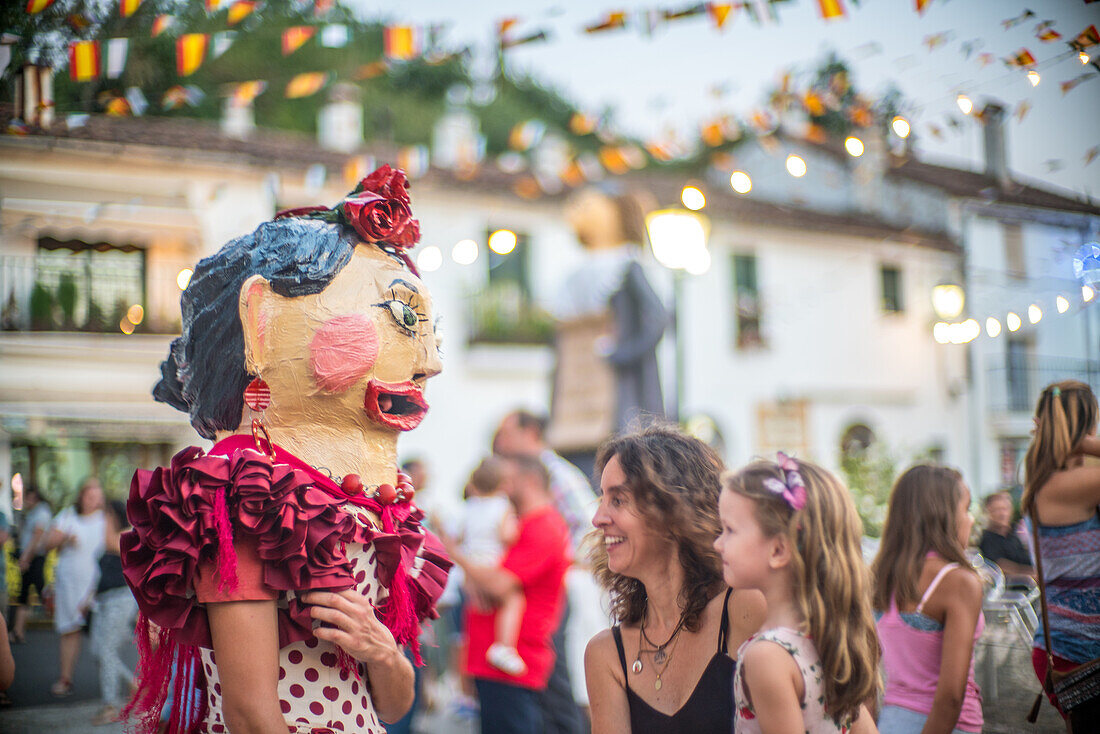 Traditional Gigantes y Cabezudos figures at the Fuenteheridos festival in Huelva, Andalucia, Spain, bringing joy to families during festivities.