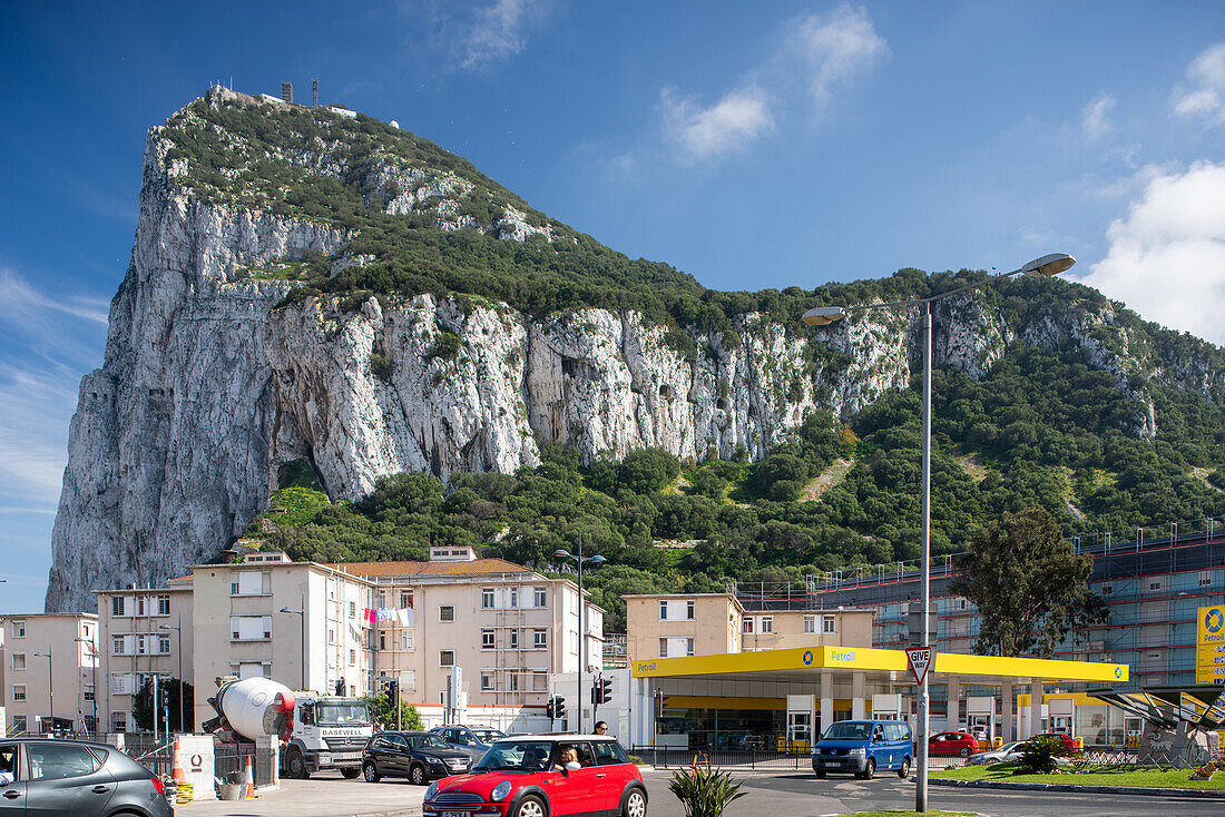 Stadtansicht mit einer Nahaufnahme des Felsens von Gibraltar. Gebäude und Fahrzeuge im Vordergrund.