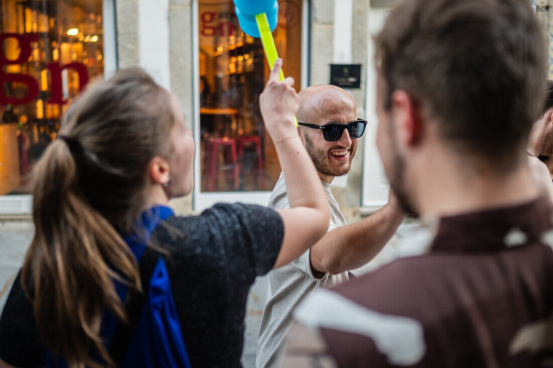 Greeting people with wilting leek and plastic hammers during Festival of St John of Porto (Festa de São João do Porto ) during Midsummer, on the night of 23 June (Saint John's Eve), in the city of Porto, Portugal