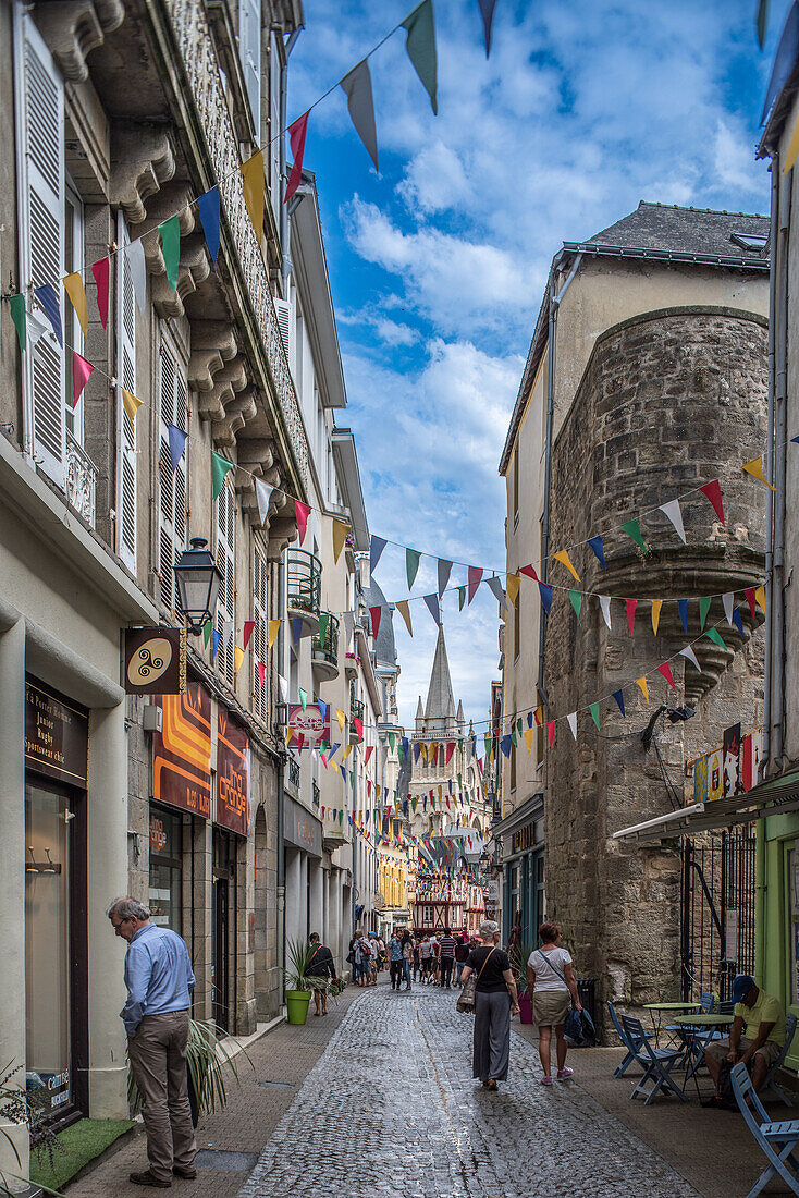 Picturesque street in Vannes, Brittany featuring Saint Pierre Cathedral and colorful flags. Captures the essence of a quaint French town.