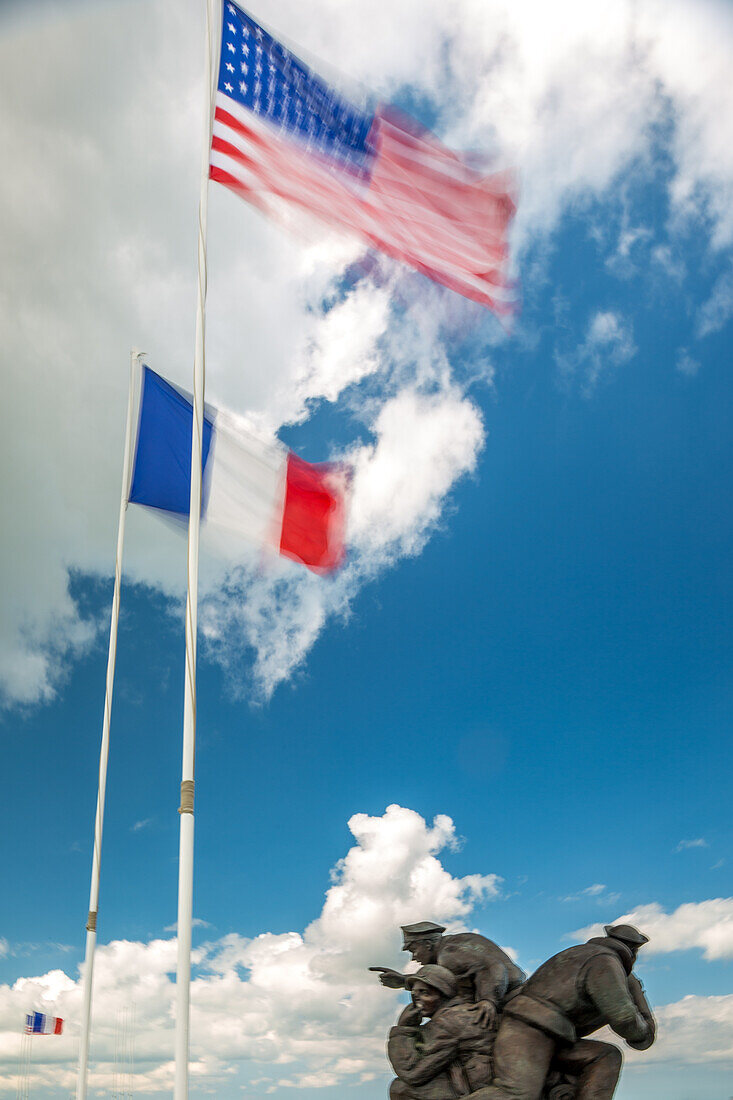 Foto eines Denkmals mit amerikanischer und französischer Flagge am Utah Beach, das an die historischen Ereignisse in der Normandie, Frankreich, erinnert.